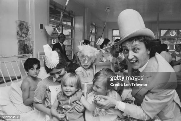 English comedian, singer and entertainer Ken Dodd pictured with nurses and patients on a ward during a visit to Great Ormond Street Hospital in...