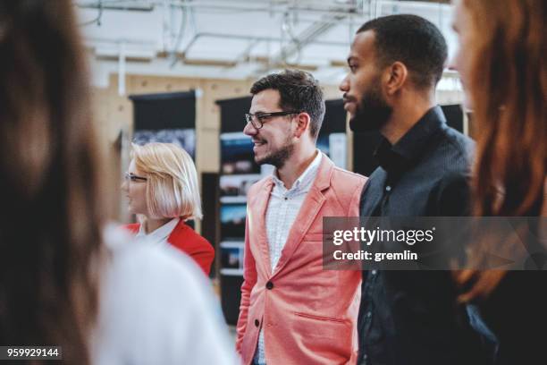 young design professionals talking in the office - exhibition stock pictures, royalty-free photos & images