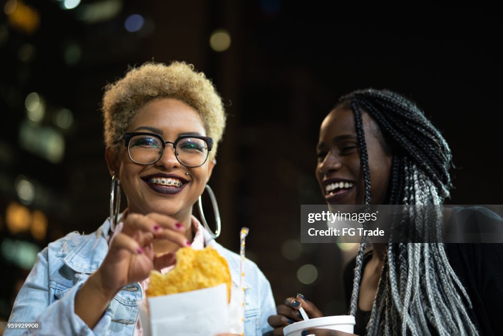仕事の後の通り 2 つ若い女性を食べるパステル