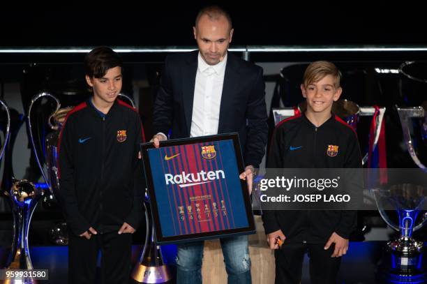 Barcelona's Spanish midfielder and captain Andres Iniesta poses with young club members during a tribute at the Camp Nou stadium in Barcelona on May...