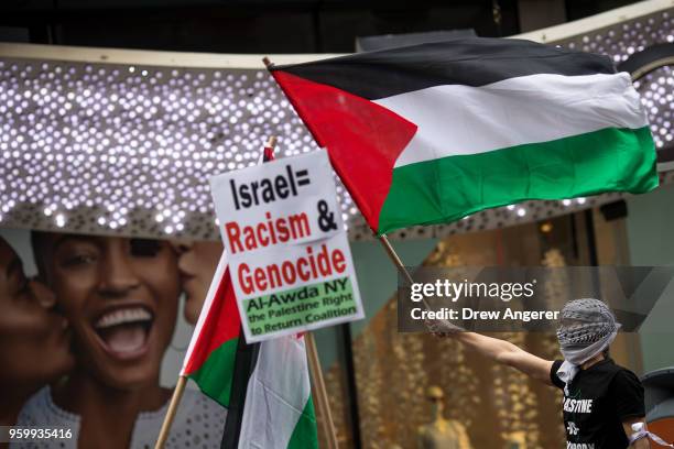 Protestor waves a Palestinian flag while standing atop a truck during rally in support of the Palestinian people in the wake of the recent violence...