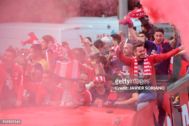 Atletico Madrid's players parade aboard an open-top bus to celebrate their Europa League victory at the Fountain of Neptune in Madrid on May 18, 2018.