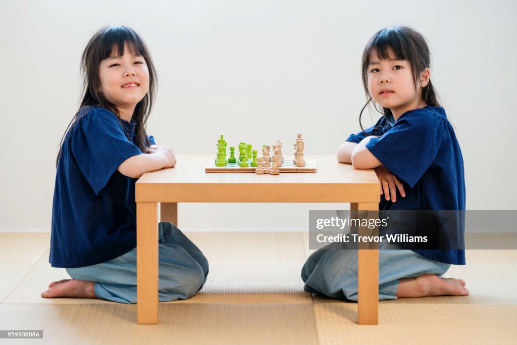 Twin girls playing chess together