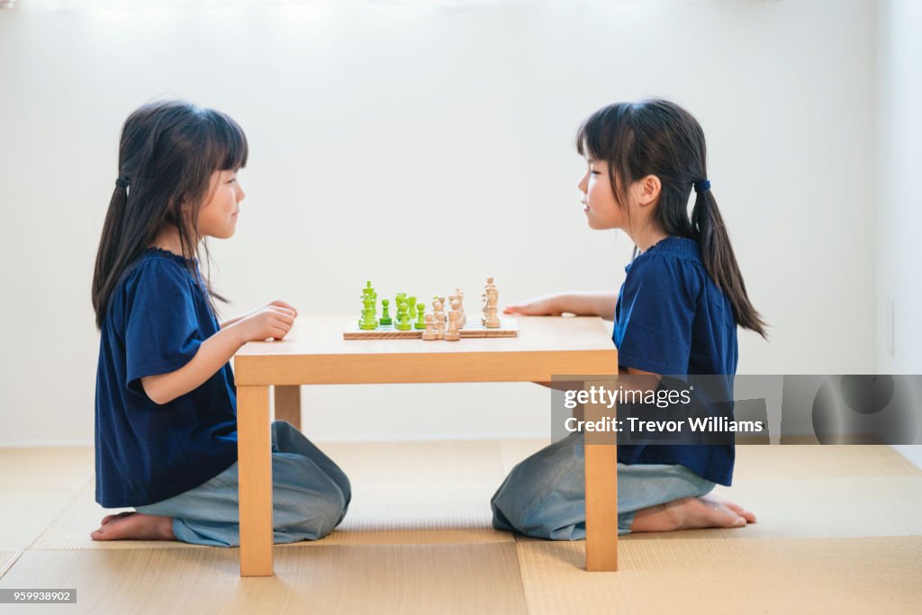 Twin girls playing chess together