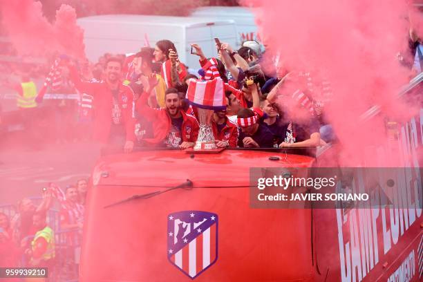 Atletico Madrid's players parade aboard an open-top bus to celebrate their Europa League victory at the Fountain of Neptune in Madrid on May 18, 2018.