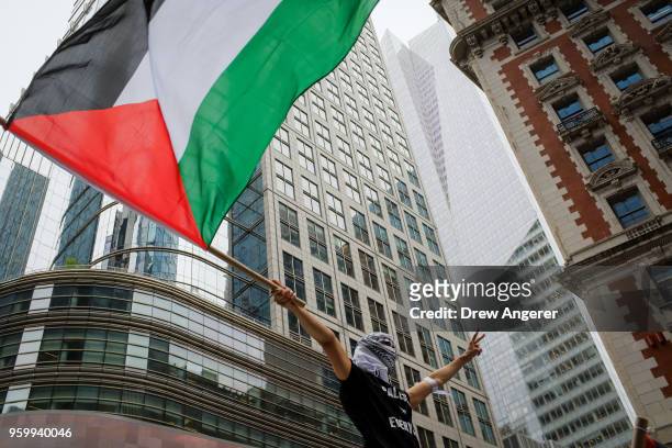 Supporter waves a Palestinian flag as members of the Palestinian community, fellow Muslims and their supporters rally in support of the Palestinian...