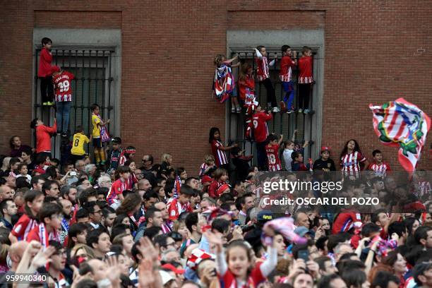 Atletico Madrid supporters wait for the team's open-top bus during a parade celebrating their Europa League victory at the Fountain of Neptune in...