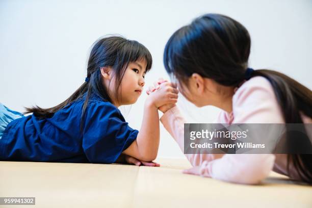 sisters arm wrestling together - stadt okayama stock-fotos und bilder