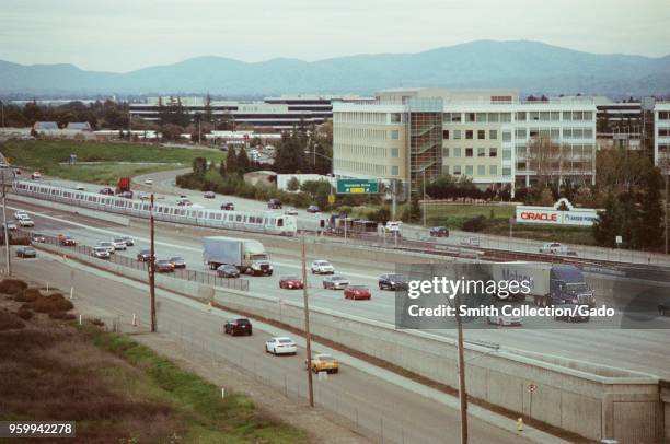 Aerial view of cars and trucks, including a Matson Lines intermodal freight container, at rush hour on the 580 freeway in Dublin, California, driving...