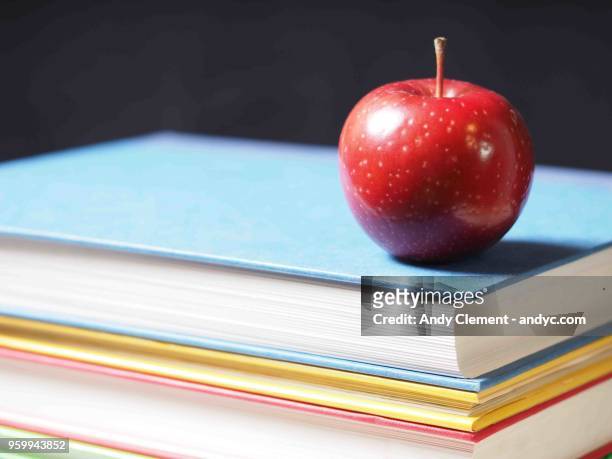 school books with apple - andy clement stock pictures, royalty-free photos & images