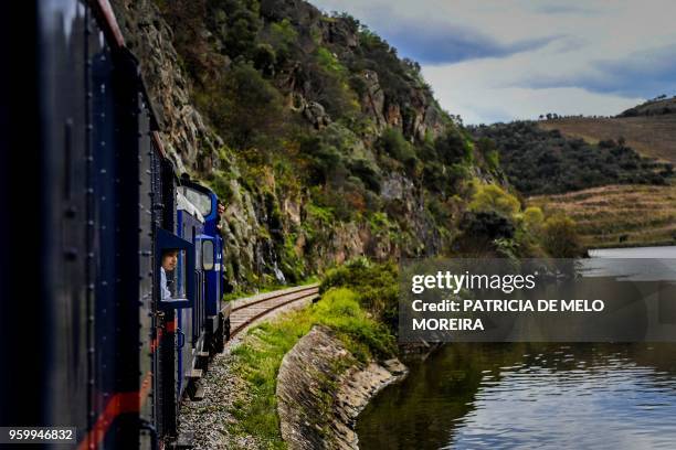 Passenger stands by a window to observe the landscape from the Presidential Train during its trip to Douro, north of Portugal, on April 8, 2018. -...