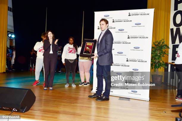 Patrick Lundquist and Michele Caplinger Sr. Executive Director of Recording Academy Atlanta Chapter present a Grammys awards trophy at the GRAMMY...