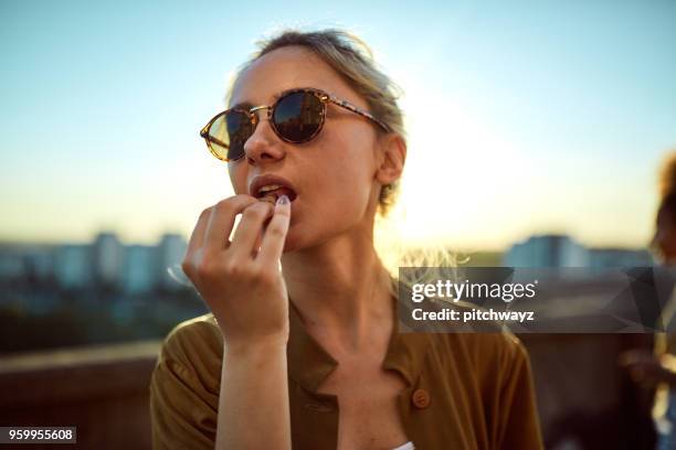 close up van vrouw snack eten. - dakterras stockfoto's en -beelden