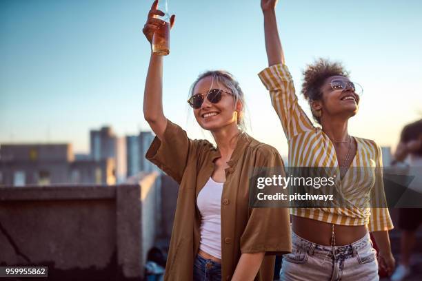 twee vrouwen juichen op dak partij. - leaving work stockfoto's en -beelden