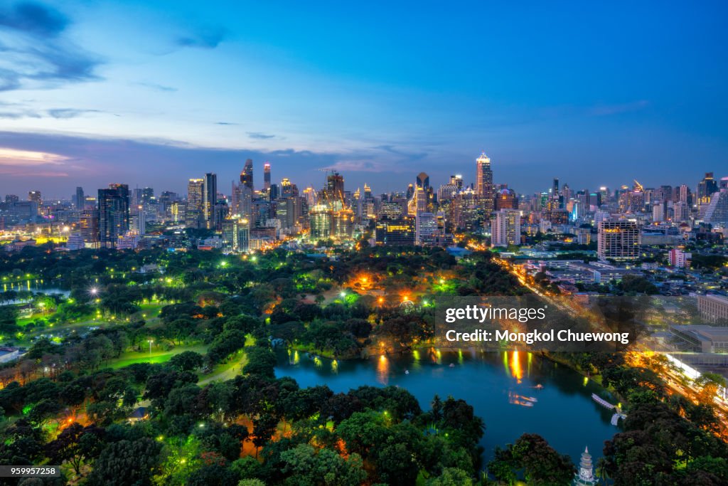 Sunset scence of Bangkok modern office buildings and condominium in Bangkok city downtown with sunset sky and clouds at Bangkok , Thailand. Lumpini park