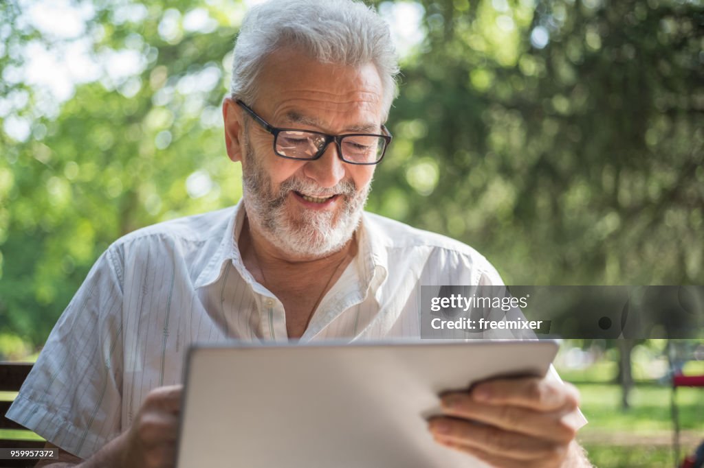 Modern senior man with tablet