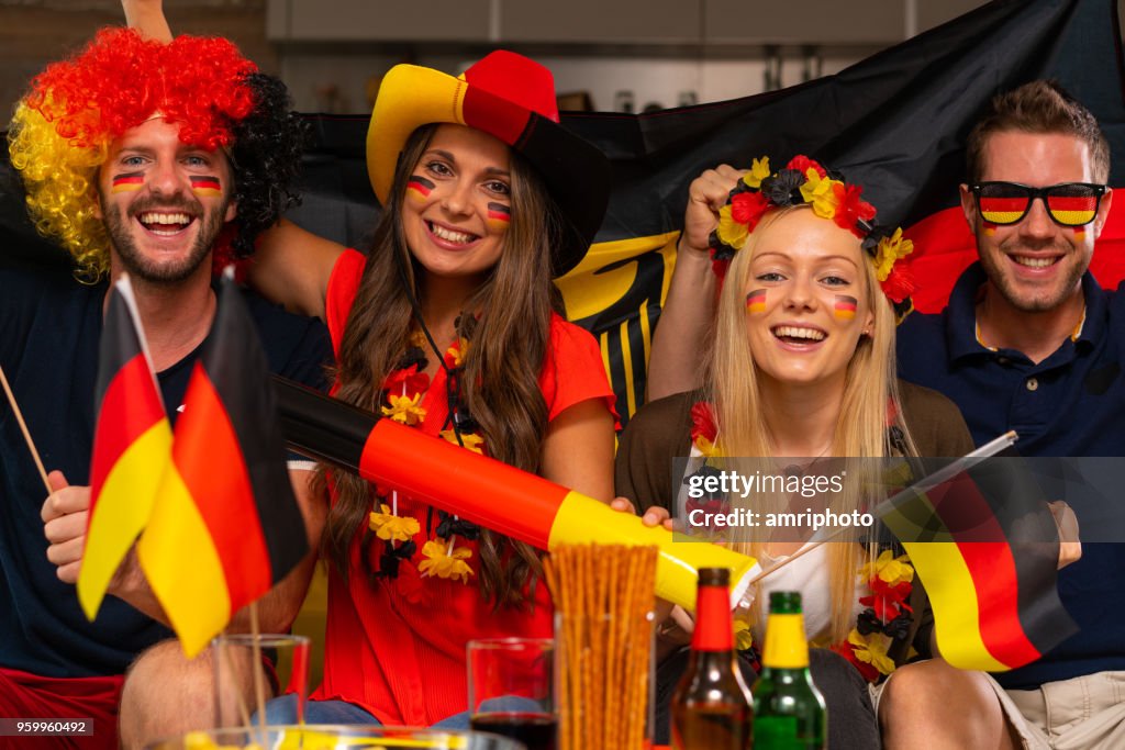 Vier glückliche deutsche Fußball-Fans zu Hause