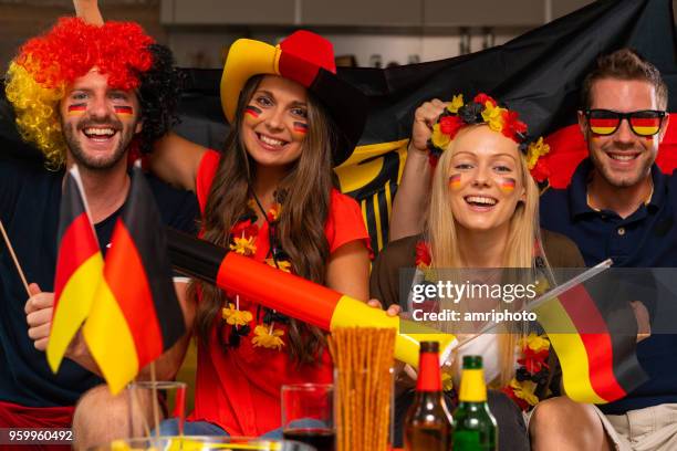 vier glückliche deutsche fußball-fans zu hause - germany soccer stock-fotos und bilder