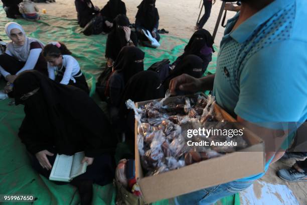 Man distributes date-palms ahead of an iftar dinner within a demonstration, on the 8th week of the "Great March of Return", at Gaza-Israel border in...