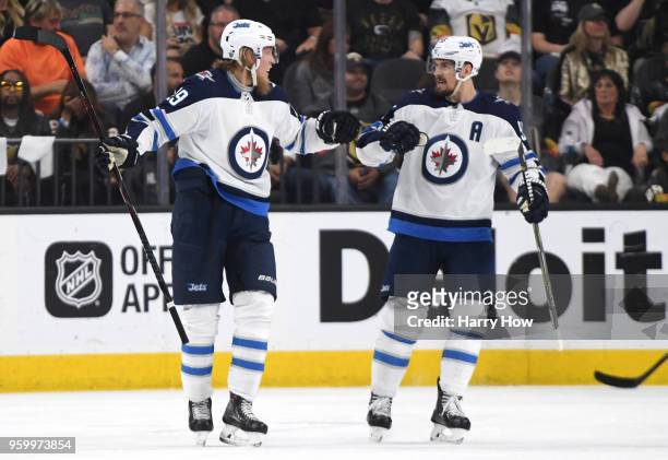 Patrik Laine is congratulated by his teammate Mark Scheifele of the Winnipeg Jets after scoring a second-period goal against the Vegas Golden Knights...