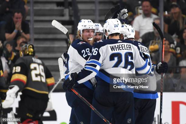 Patrik Laine of the Winnipeg Jets is congratulated by his teammates after scoring a second-period goal as Marc-Andre Fleury of the Vegas Golden...