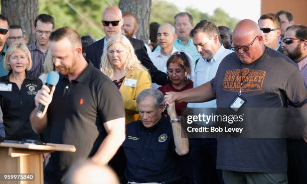 Texas Governor Greg Abbott holds hands with family and friends at a vigil held at the First Bank in Santa Fe for the victims of a shooting incident...