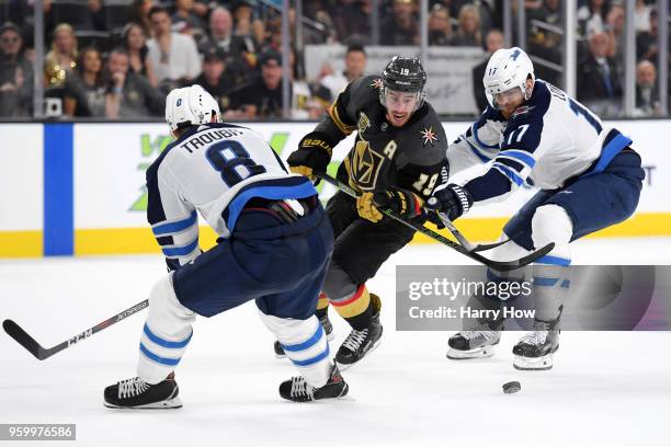 Reilly Smith of the Vegas Golden Knights is defended by Jacob Trouba and Adam Lowry of the Winnipeg Jets during the second period in Game Four of the...