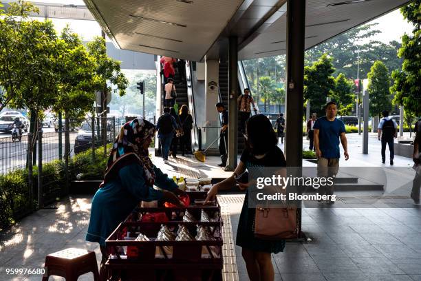 Woman, center, purchases food from a street vendor in Kuala Lumpur, Malaysia, on Friday, May 18, 2018. Malaysian Prime Minister Mahathir Mohamad's...