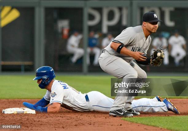 Whit Merrifield of the Kansas City Royals slides into second for a steal past Ronald Torreyes of the New York Yankees in the third inning at Kauffman...