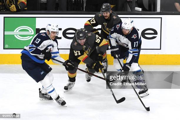 David Perron of the Vegas Golden Knights is defended by Brandon Tanev and Adam Lowry of the Winnipeg Jets during the second period in Game Four of...