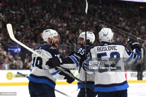 Bryan Little, Mathieu Perreault and Jack Roslovic of the Winnipeg Jets celebrate a third-period goal by their teammate Tyler Myers against the Vegas...