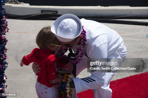 Families and friends hugging and celebrating the arrival of the Arleigh Burke-class guided-missile destroyer USS Halsey at Joint Base Pearl...