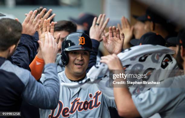 Victor Martinez of the Detroit Tigers is congratulated by teammates in the dugout after scoring a run on a double by John Hicks of the Detroit Tigers...