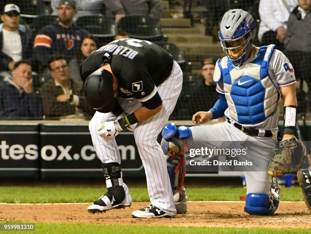 Nicky Delmonico of the Chicago White Sox reacts after being hit by a pitch as Robinson Chirinos of the Texas Rangers looks on during the second...