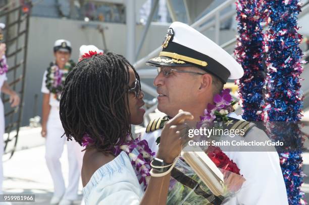 Families and friends hugging and celebrating the arrival of the Arleigh Burke-class guided-missile destroyer USS Halsey at Joint Base Pearl...