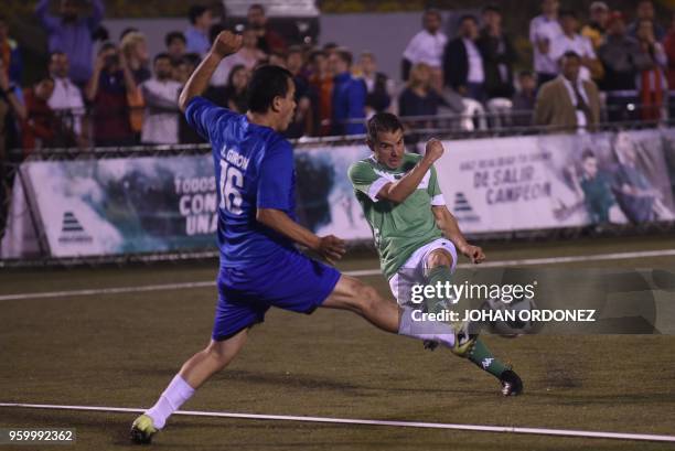 Former Argentine footballer player Javier Saviola vies for the ball with fellow former footballer, Guatemalan Julio Giron during an exhibition match...