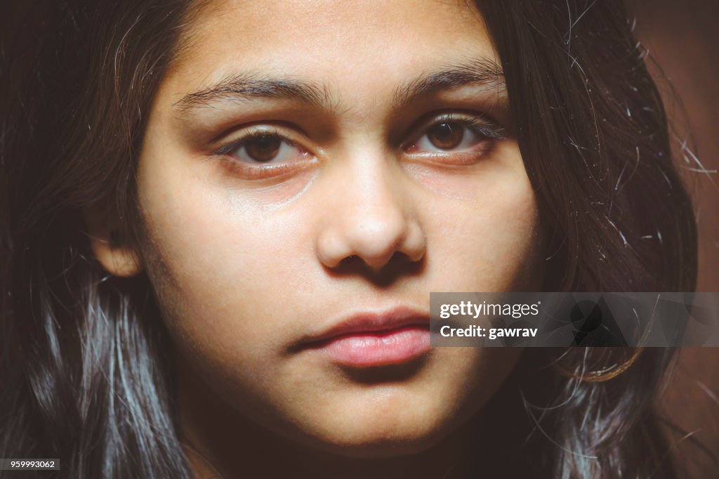 Teenager girl contemplating and looking at camera.