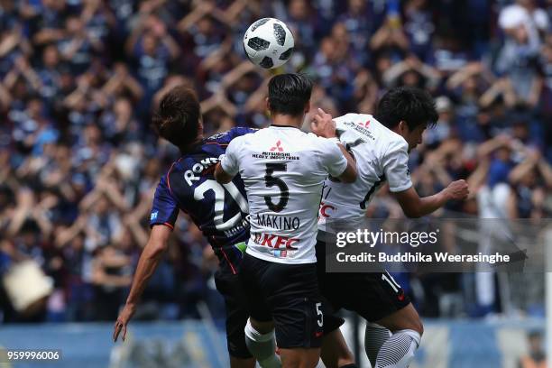 Shun Nagasawa of Gamba Osaka competes for the ball against Tomoaki Makino and Takuya Aoki of Urawa Red Diamonds during the J.League J1 match between...