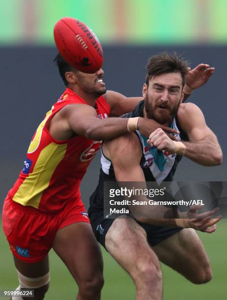 Charlie Dixon of the Power attempts to break a tackle from Aaron Hall of the Suns during the 2018 AFL round nine match between the Gold Coast Suns...