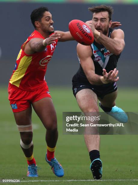 Charlie Dixon of the Power attempts to break a tackle from Aaron Hall of the Suns during the 2018 AFL round nine match between the Gold Coast Suns...