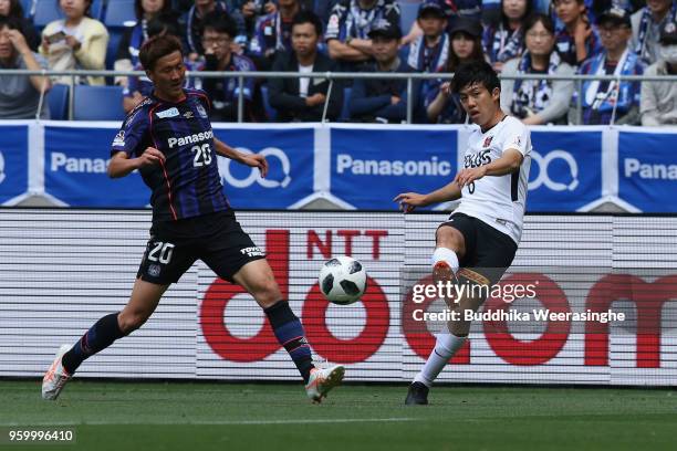 Wataru Endo of Urawa Red Diamonds passes the ball under pressure of Shun Nagasawa of Gamba Osaka during the J.League J1 match between Gamba Osaka and...