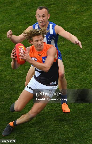 Lachie Whitfield of the Giants is tackled by Billy Hartung of the Kangaroos during the round nine AFL match between the North Melbourne Kangaroos and...