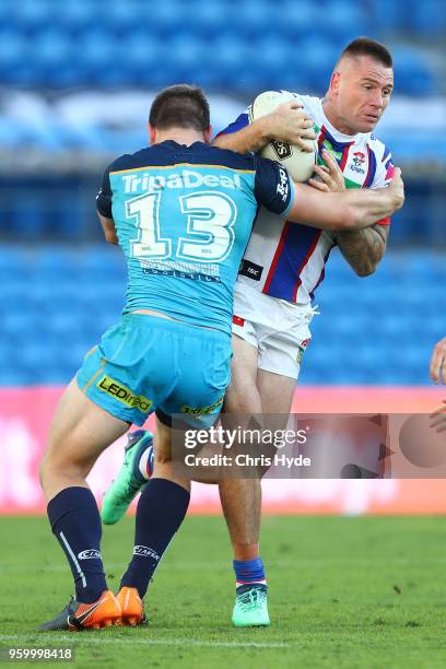 Shaun Kenny-Dowall of the Knights is tackled during the round 11 NRL match between the Gold Coast Titans and the Newcastle Knights at Cbus Super...