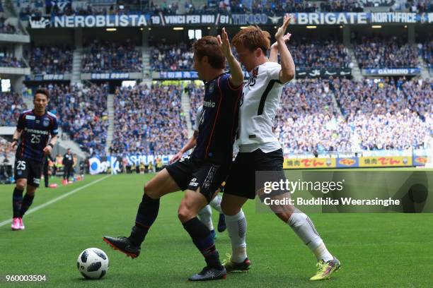 Koki Yonekura of Gamba Osaka and Tomoya Ugajin of Urawa Red Diamonds compete for the ball during the J.League J1 match between Gamba Osaka and Urawa...