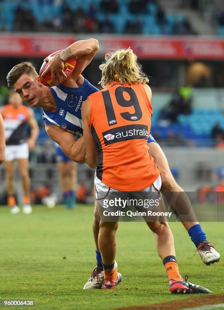 Jy Simpkin of the Kangaroos is tackled by Nick Haynes of the Giants during the round nine AFL match between the North Melbourne Kangaroos and the...