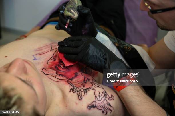 Tattoo artist makes a tattoo for festival attendee during the International Tattoo Convention &quot;Tattoo Collection 2018&quot; in Kyiv, Ukraine,...