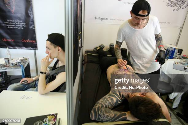 Tattoo artist makes a tattoo for festival attendee during the International Tattoo Convention &quot;Tattoo Collection 2018&quot; in Kyiv, Ukraine,...