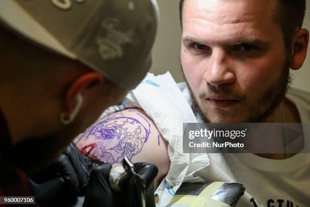 Tattoo artist makes a tattoo for festival attendee during the International Tattoo Convention &quot;Tattoo Collection 2018&quot; in Kyiv, Ukraine,...