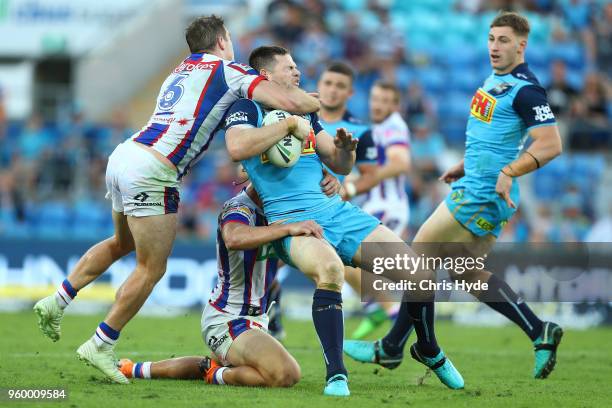 Anthony Don of the Titans is tackled by Connor Watson of the Knights during the round 11 NRL match between the Gold Coast Titans and the Newcastle...