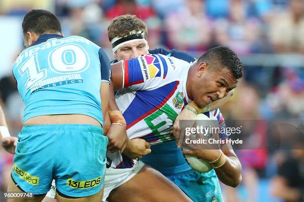 Jacob Saifiti of the Knights is tackled during the round 11 NRL match between the Gold Coast Titans and the Newcastle Knights at Cbus Super Stadium...